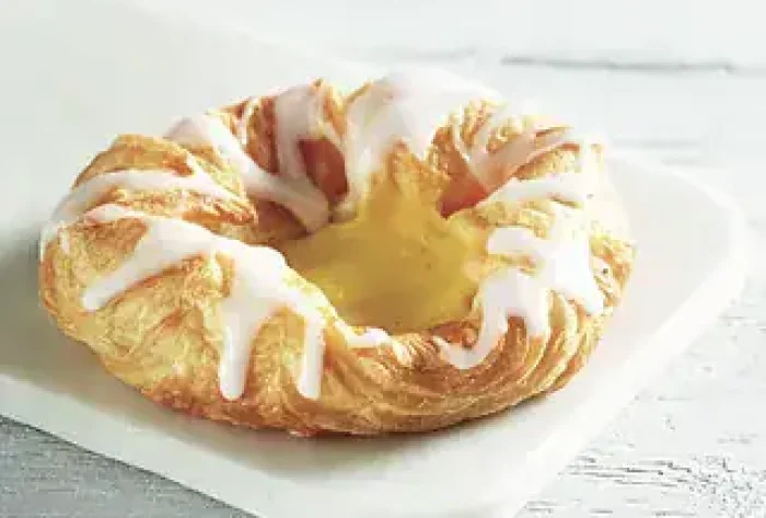 Nydelig kake med krem, frukt og dekorative detaljer, perfekt for festlige anledninger.